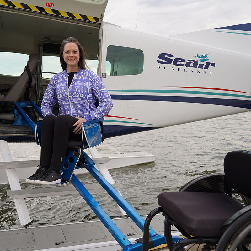 Woman sitting on a chair in the mobility lift as it ascends to the seaplane Woman sitting on a chair in the mobility lift as it ascends to the seaplane