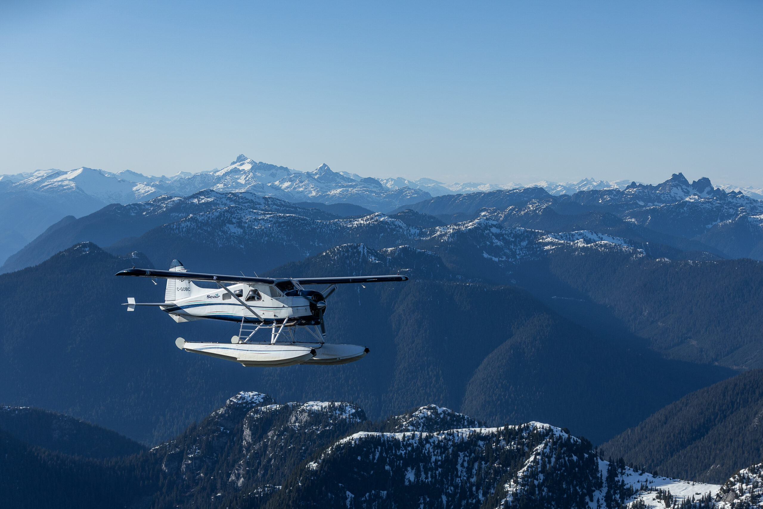 Seaplane flying over the coastal mountains